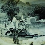 Jean in front of the Caterpillar - International Magazine Kreol Jean in front of the Caterpillar tractor, used to remove stones to channel water during dry season, Uganda