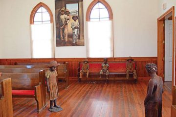 Terra-cotta statues of child slaves are inside of a church at the Whitney Plantation