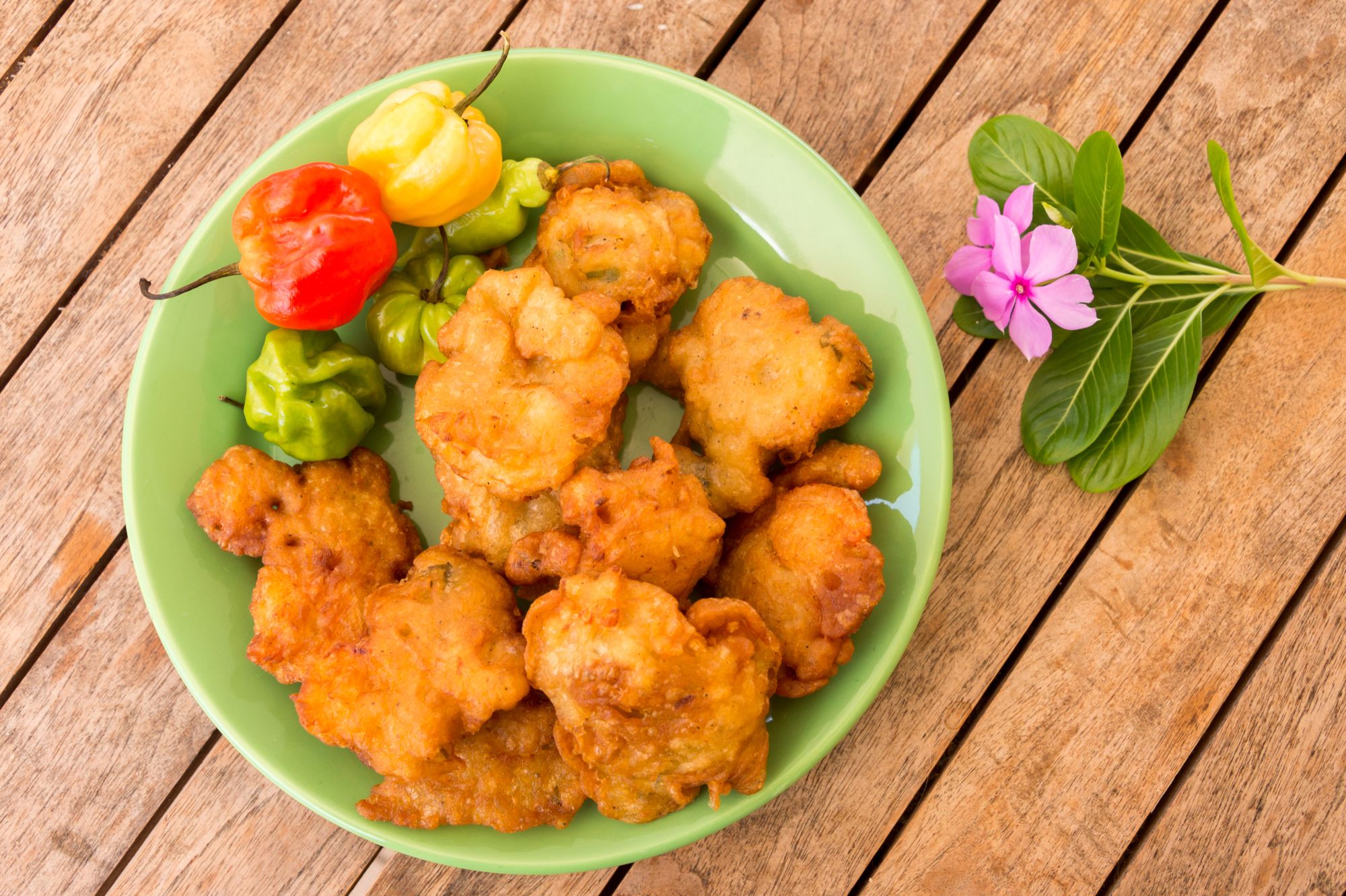 Salt Cod Fritters on a plate with habanero pepepers in Martinique - International Magazine Kreol Salt Cod Fritters on a plate with habanero peppers in Martinique