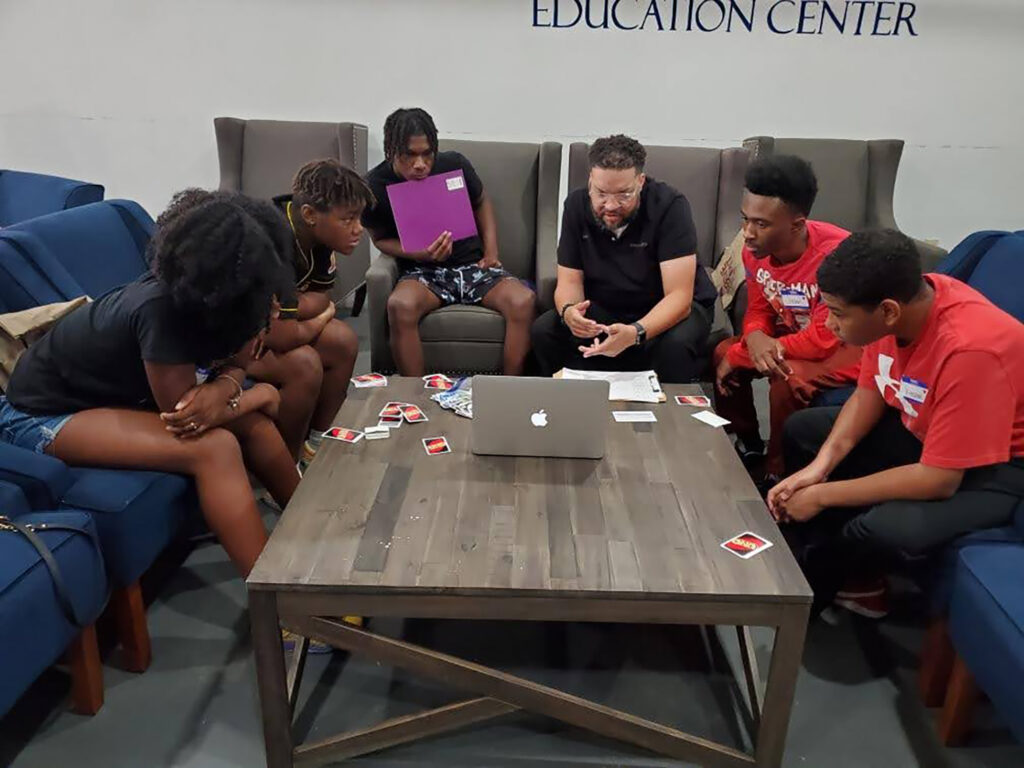 Broussard - International Magazine Kreol Brent speaks with a group of youth at a financial literacy camp.
