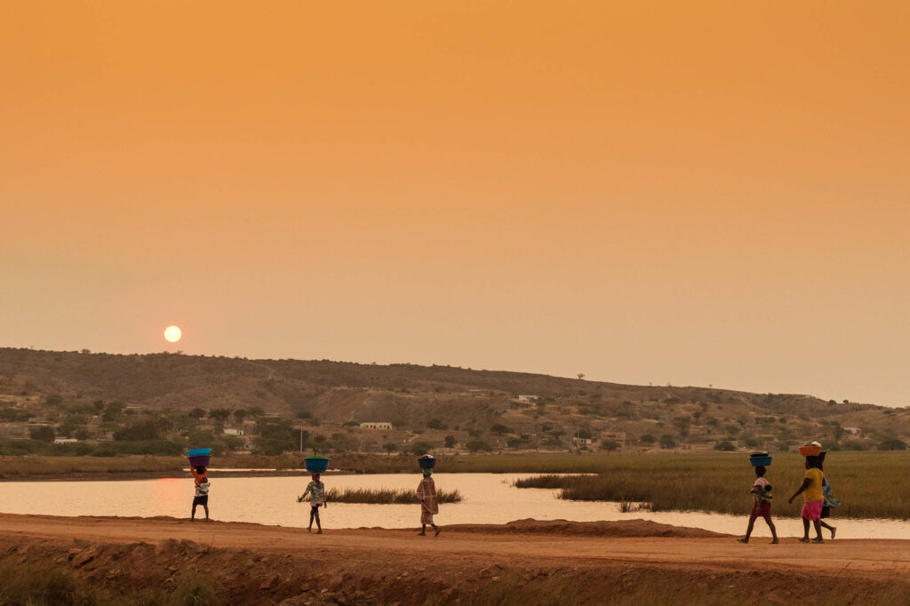 AfricanRuralPeopleReturningFromWorkWithSunsetSumbeAngola - International Magazine Kreol African rural people returning from work, with sunset. Sumbe. Angola.