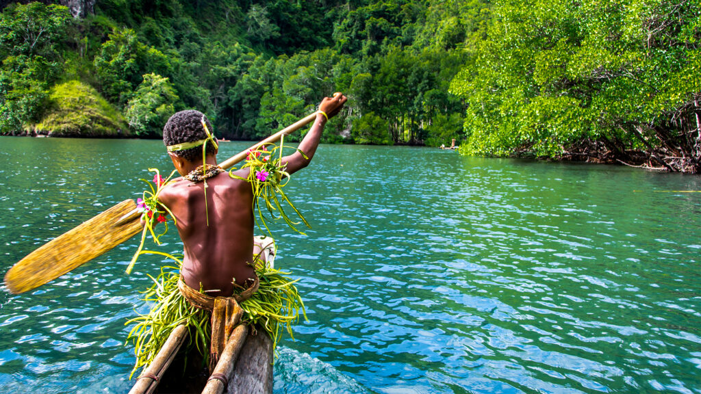 Sportive indigenous tribal boy with a paddle in a traditional canoe, Melanesia, Papua New Guinea, Tufi - International Magazine Kreol Yang sportive indigenous tribal boy with a paddle in a traditional canoe, Melanesia, Papua New Guinea, Tufi
